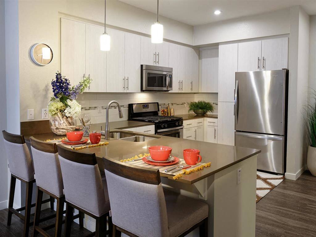 a kitchen with a center island and a stainless steel refrigerator